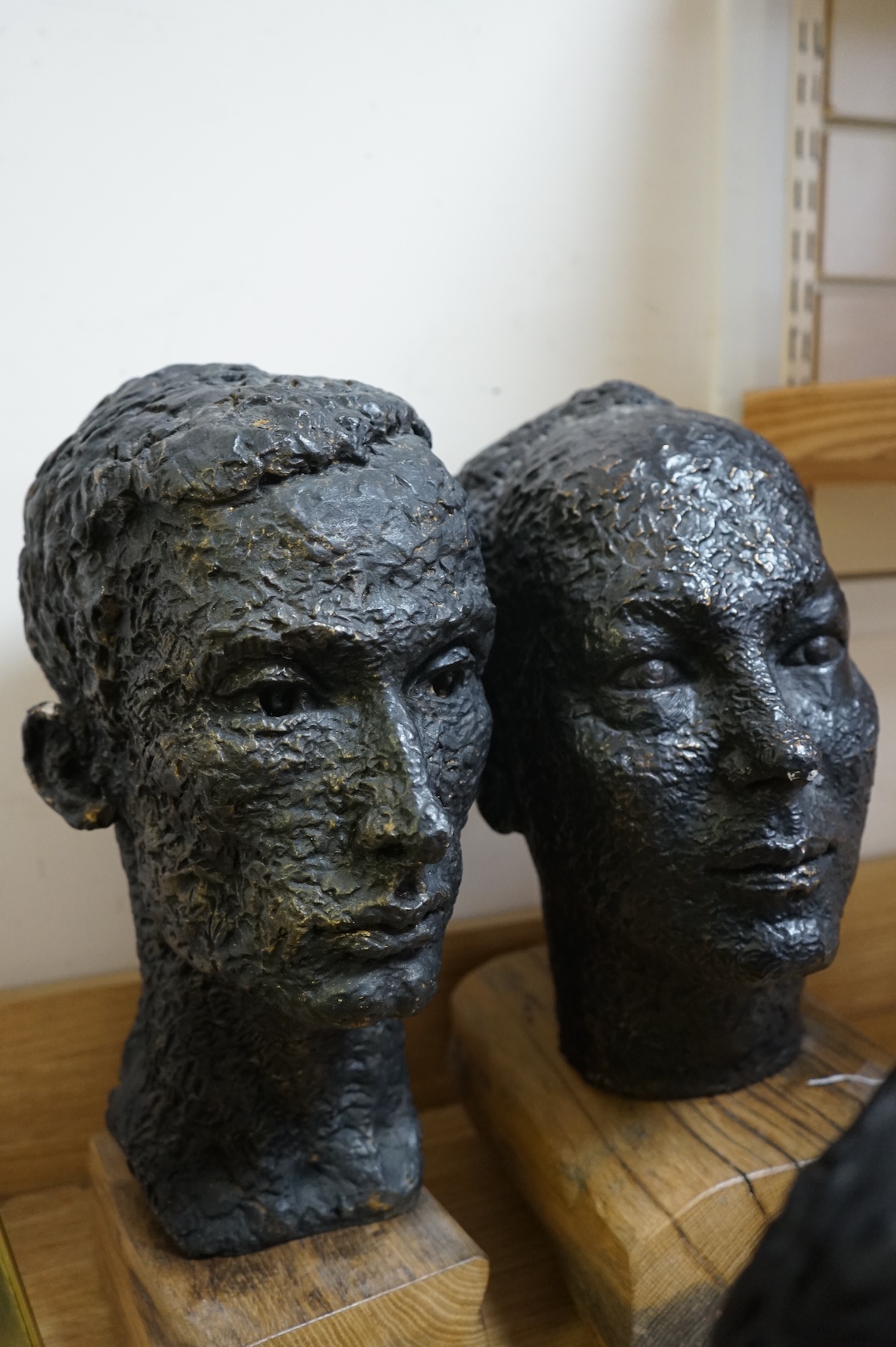 Six black painted composition heads, by Hazel Armour, tallest 49cm